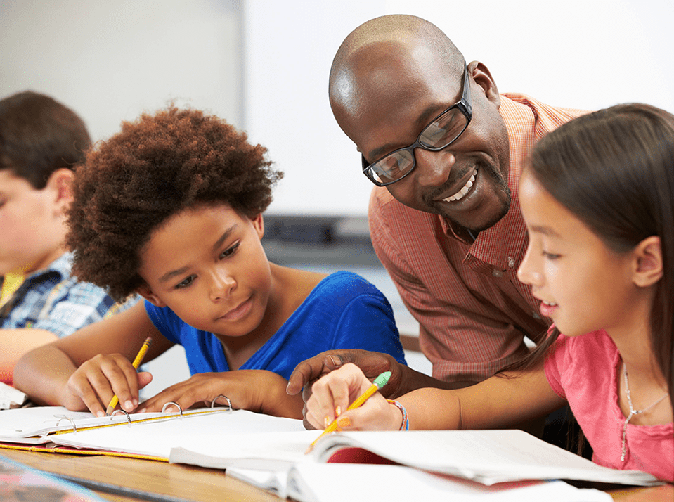 Special education teacher working with two students on a lesson.